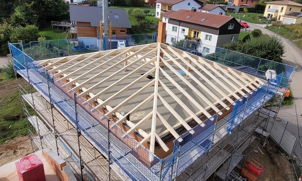 Neue Walmdachkonstruktion aus Holz für ein Massivhaus